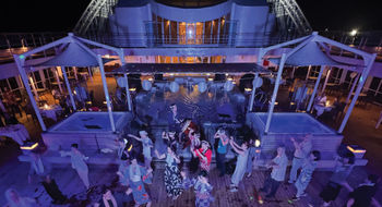 Mitsui Ocean Cruises passengers dance on the deck of the Ocean Fuji during the summer festival party.