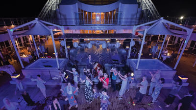 Mitsui Ocean Cruises passengers dance on the deck of the Ocean Fuji during the summer festival party.