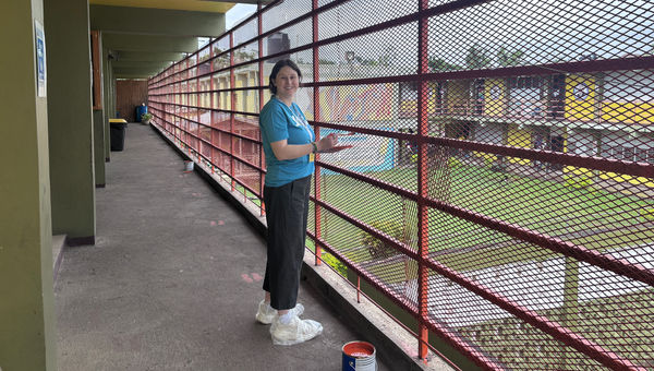 Senior tours editor Brinley Hineman paints at Catherine Hall School in Montego Bay.