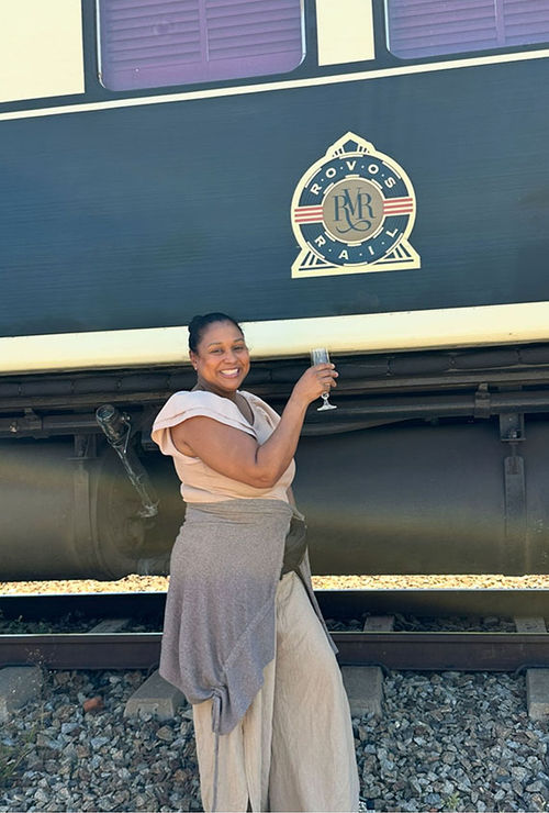 The author in front of a Rovos Rail Luxury Train car in Hwange National Park, Zimbabwe.