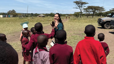 Sandra Solis, Abercrombie & Kent Philanthropy’s (AKP) coordinator in Peru, high-fives students in Kenya’s Masai Mara.
